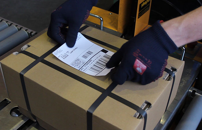 Etikett wird auf Paket geklebt